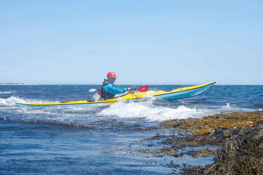 Person kayaking in the Atlantic ocean with a clear blue sky